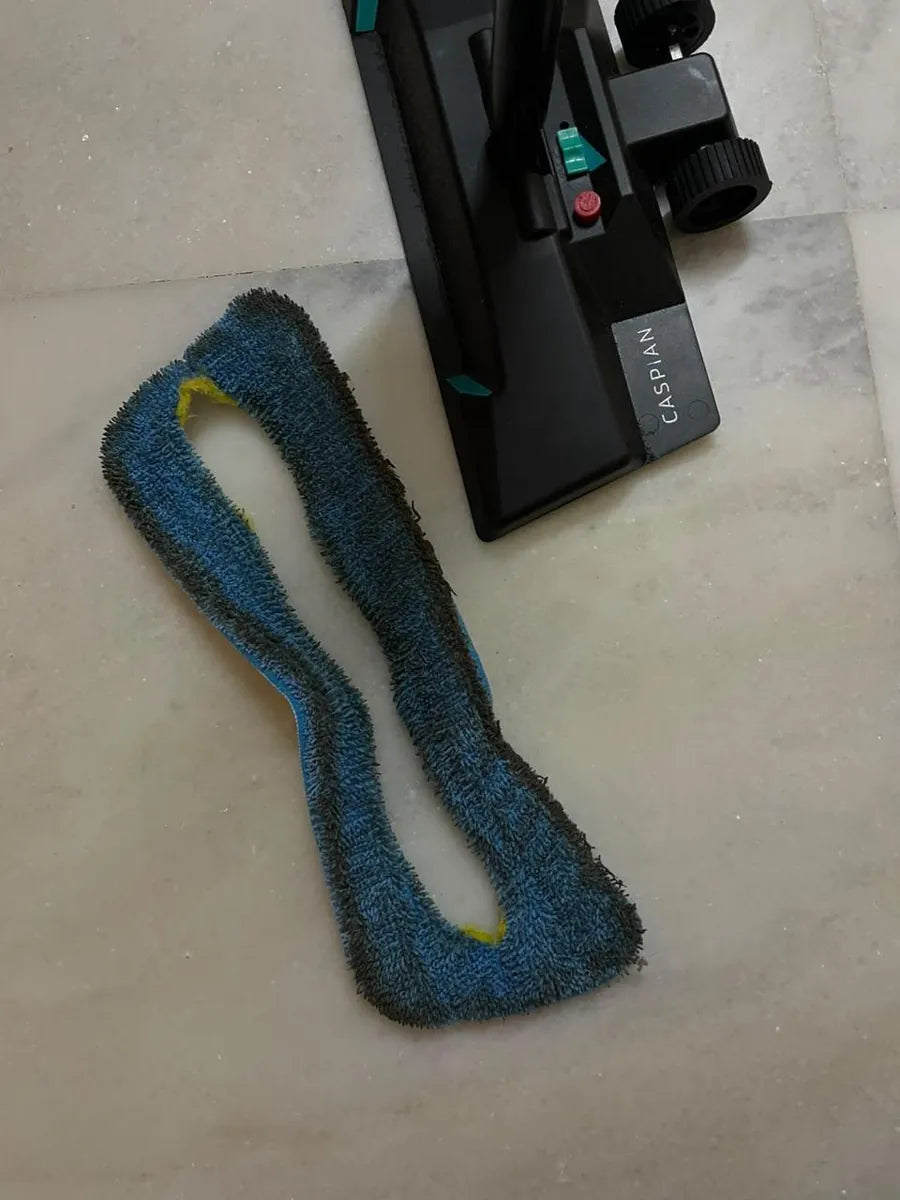 A blue SmartMop microfiber pad, grey with dirt, beside the SmartMop base